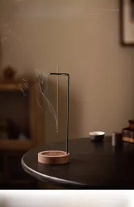 Detailed view of an upside-down incense burner with wood base and black metal stand