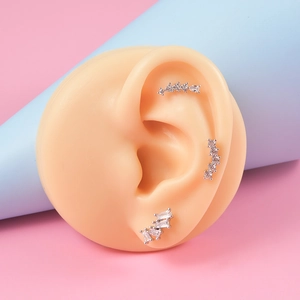 Détail de boucles d'oreilles en argent et zircon sur un modèle d'oreille en silicone