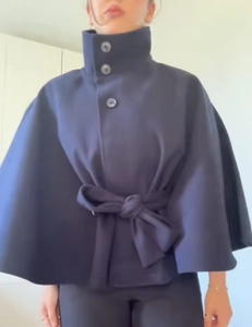 Deep blue poncho coat featuring high stand collar and matching waist belt detail