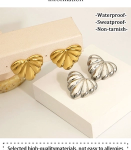 Detail view of fan-shaped shell textured earrings in polished gold and silver finishes