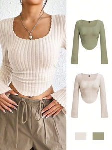 Detail of ribbed knit long sleeve crop top with round neck and curved hemline