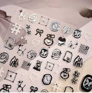 Close-up of embossed silver nail stickers with butterfly and star motifs on light background
