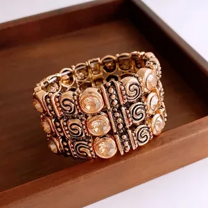 Vintage style gold-plated elastic bracelet with amber crystals and spiral relief design
