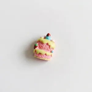 Three-layer pink resin cake miniature with yellow frosting and strawberry for DIY crafts