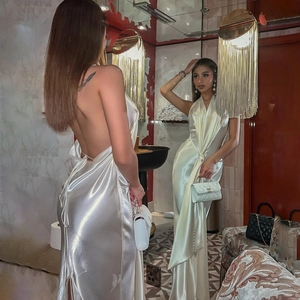 Robe longue blanche en satin dos nu avec laçage et fente haute vue dans un miroir