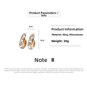 Detailed view of gold C-shaped earrings with rhinestones, 3cm width by 4cm height size