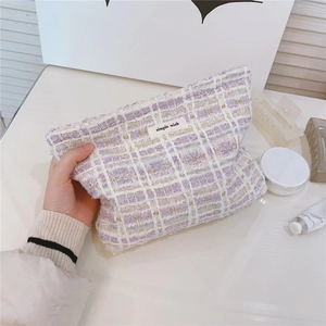 Detailed shot of purple and white tweed makeup bag with simple wish brand label