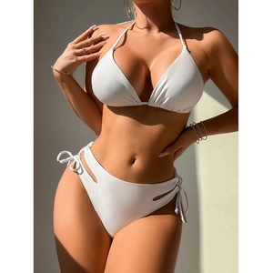 Detail of white high-waist bikini bottoms featuring unique side cut-outs and tie-up strings