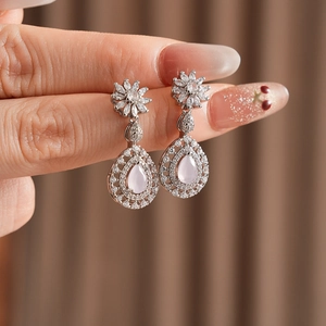 Detail of silver drop earrings with pink water-drop stones and zircon flower studs
