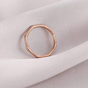 Elegant rose gold bamboo style stainless steel ring on soft purple silk fabric