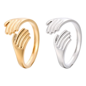 Close-up of gold and silver hugging hands open rings with polished steel finish