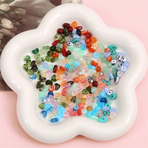 Colorful irregular acrylic droplet beads in a white dish for DIY handmade jewelry making