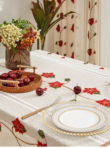 Detail of festive embroidered red poinsettia flowers and lace hollow design on tablecloth