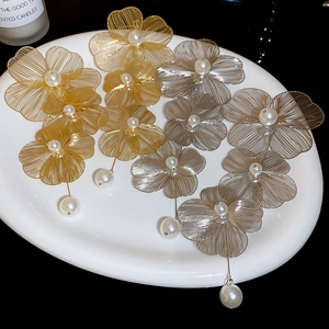 Macro di orecchini a fiore con petali in filo metallico traforato e pendenti di perle