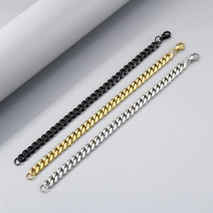 Tre bracciali a catena cubana in nero, oro e argento esposti su uno sfondo grigio neutro