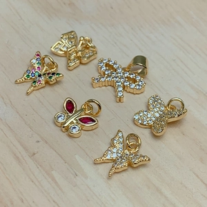 Detailed view of six gold butterfly pendants with zircon and colorful rhinestones