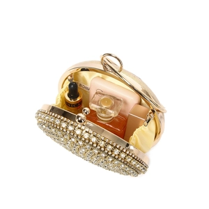 Detail of opened crystal evening bag with gold metal frame and yellow satin lining storage