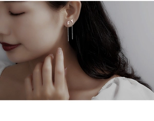 Close-up of S999 sterling silver letter F and Y tassel drop earrings on model