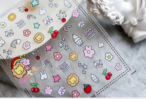 Detail of transparent nail stickers featuring cute cartoon animals and floral patterns