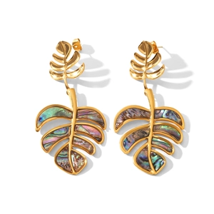 Close-up of golden monstera leaf earrings with shimmering colorful shell inlay texture