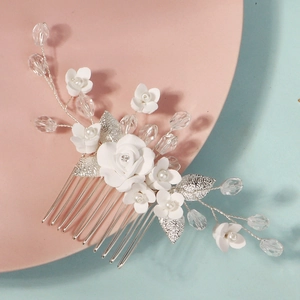 Detailsicht des silbernen Braut-Haarkamms mit weißen Blumen, Kristallperlen und Metallblättern