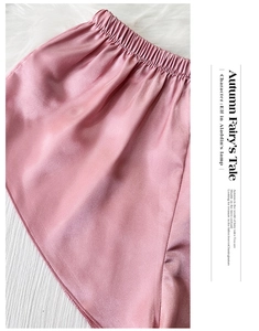 Détail du short de détente en satin rose avec taille élastique et texture soyeuse lisse