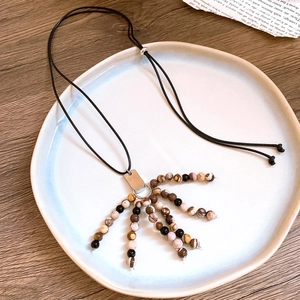 Detailed close-up of Zen style tassel necklace with mixed beads and silver metal accents