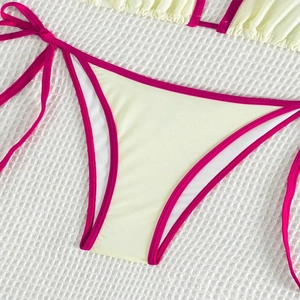 Detail of light yellow bikini bottom with magenta contrast piping and side tie design