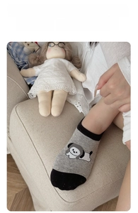 Close-up of thin grey cotton no-show socks with a cute cartoon dog pattern
