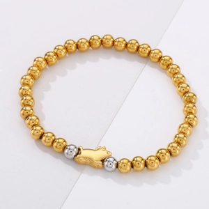 Detailed close-up of golden beaded elastic bracelet featuring a cute pig charm