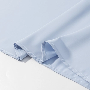 Detail of light blue fabric showing professional double-needle stitching and texture