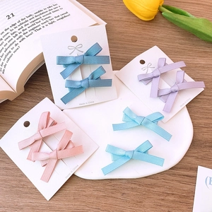 Detail of sweet satin ribbon bow hair clips in pastel blue, purple, and pink colors