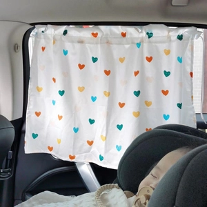 Detailed view of colorful heart pattern sunshade curtain installed in a car window