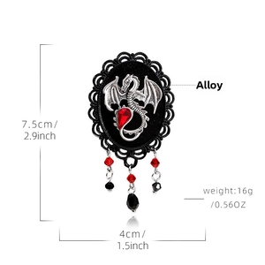 Detail view of gothic dragon brooch with red waterdrop rhinestone and bead tassels