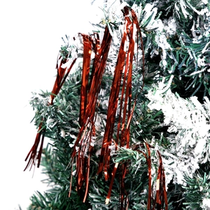 Red metallic foil fringe curtain decoration on snow-covered Christmas tree branches