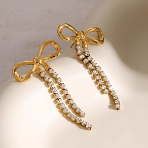 Close-up of 18k gold-plated bow earrings with shimmering rhinestone tassel chains