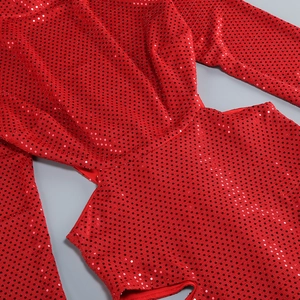 Détail de la robe à paillettes rouges avec découpe à la taille et texture scintillante