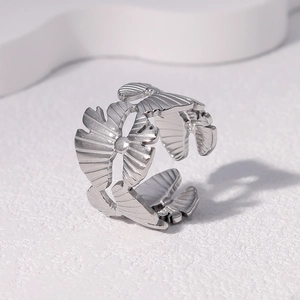 Macro detail of silver ginkgo leaf ring showing intricate vein textures and steel finish