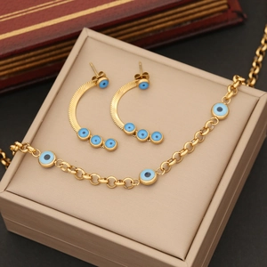 Parure de bijoux en acier doré avec breloques œil bleu sur une chaîne à maillons