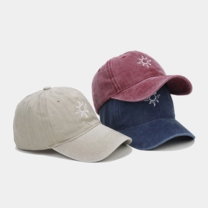 Detailed embroidery on vintage washed cotton baseball caps in beige, burgundy, and navy colors