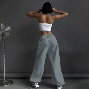 Dettaglio dei pantaloni cargo grigi a vita alta in tessuto leggero e stile streetwear