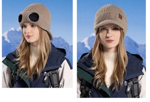 Detail of beige ribbed knit winter hat featuring integrated aviator goggles and ear flaps