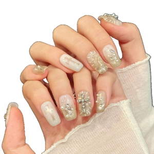 Elegant white press-on nails featuring silver cross charms, pearls, and champagne glitter