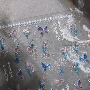 Holographic laser nail stickers with butterfly and flower designs in metallic finish