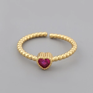 Detail of adjustable 18k gold plated ring featuring a red heart-shaped gemstone and beads
