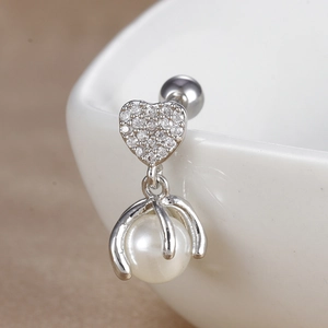 Détail macro d'une boucle d'oreille cœur avec zircone et perle blanche suspendue