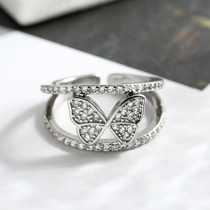 Macro detail of silver butterfly ring with micro-pave cubic zirconia stones and dual-band design