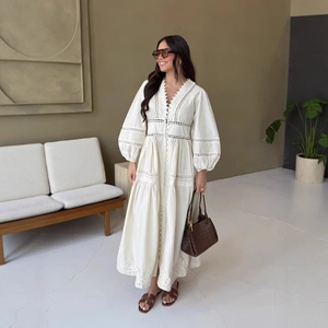 Elegante abito lungo bianco con scollo a V, pizzo traforato e maniche a sbuffo