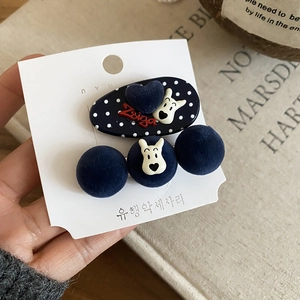 Detail showing flocked dog hair clips in navy blue with dots and red heart accent