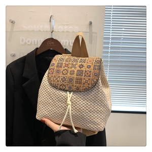 Detail of hand-woven straw bucket backpack with artistic geometric flap and drawstring closure